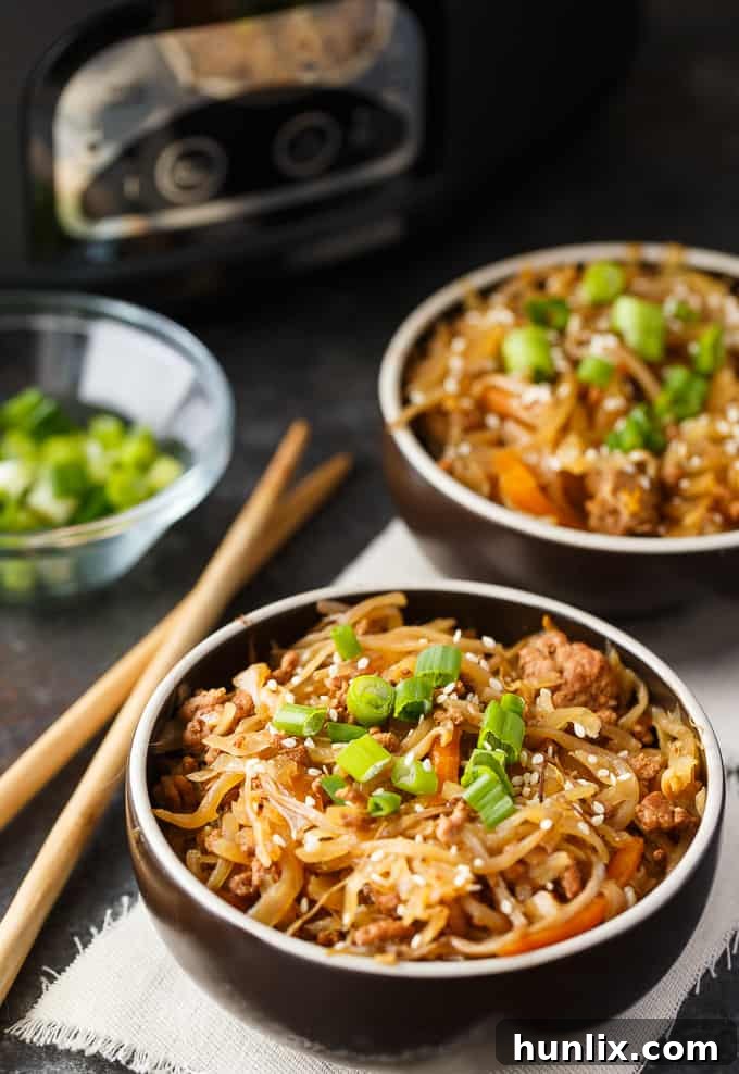 A bowl of Egg Roll in a Bowl, garnished with green onions and sesame seeds, showcasing the rich colors and textures of the dish.