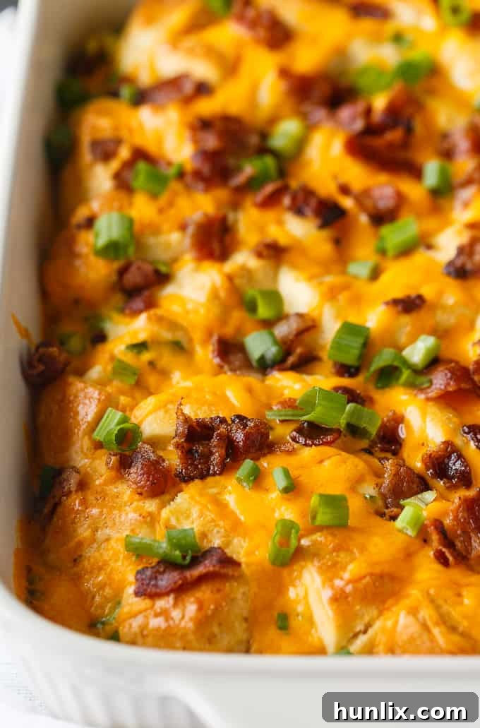 Close-up of a bubbling Bacon and Egg Biscuit Casserole, highlighting the golden biscuits and melted cheese.