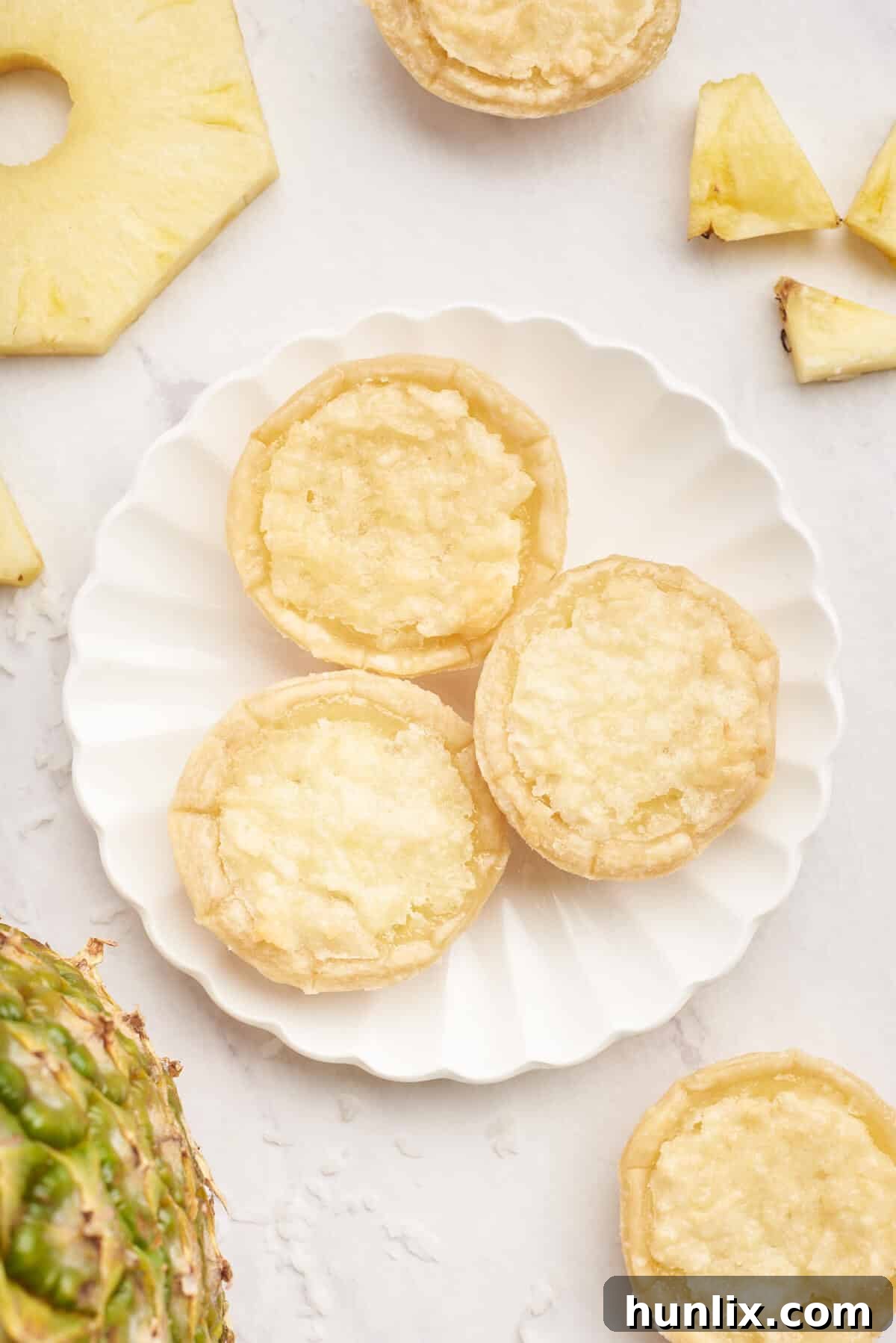 Three pineapple tarts on a plate.