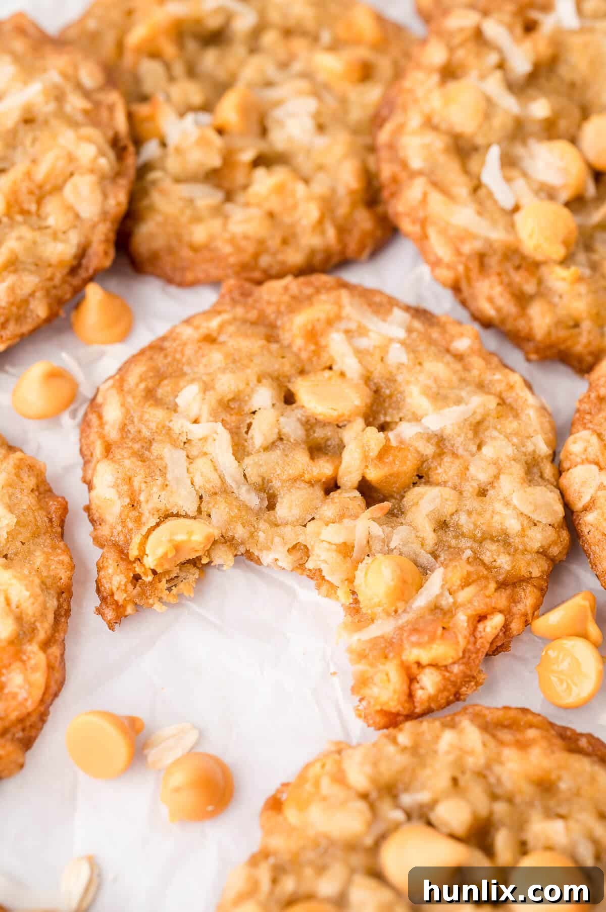 A single coconut butterscotch cookie with a bite taken out, showing its soft interior and embedded chips.