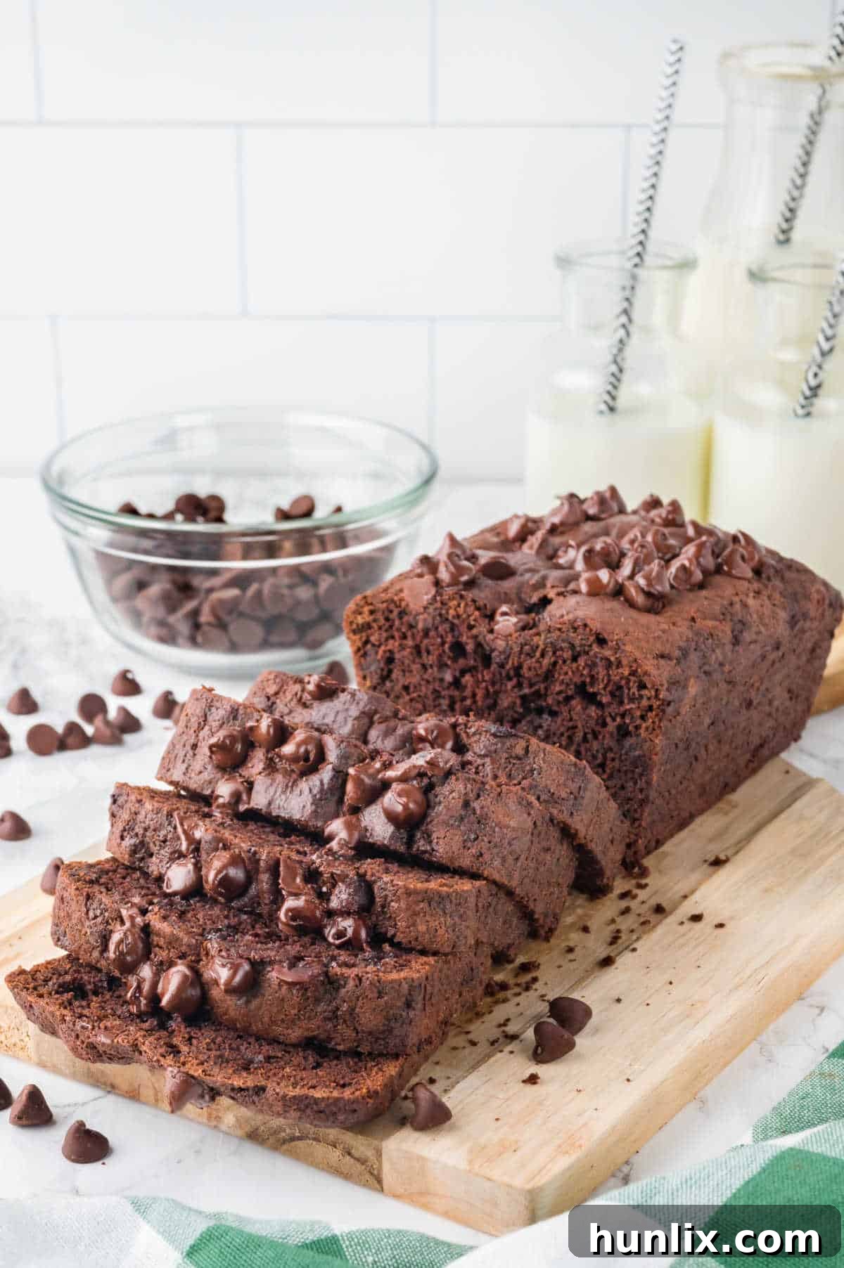 A loaf of chocolate zucchini bread cut into slices, showing the chocolate chips throughout.