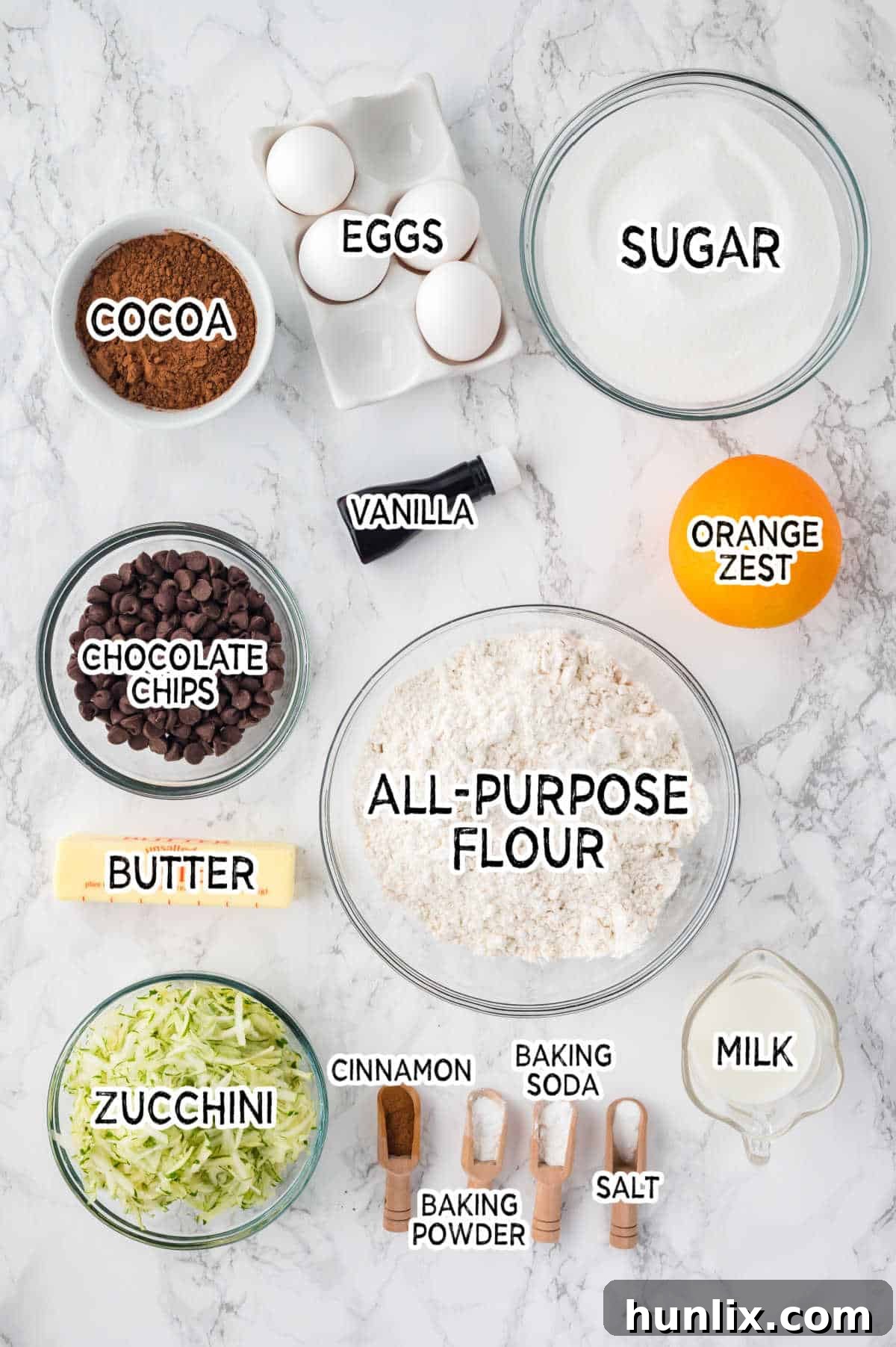 A collection of ingredients laid out for making chocolate zucchini bread.