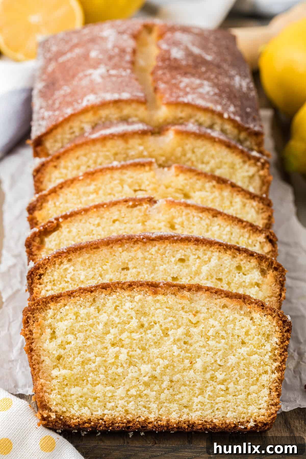 Sliced lemon bread loaf on a cutting board, showcasing its moist texture and golden crust.