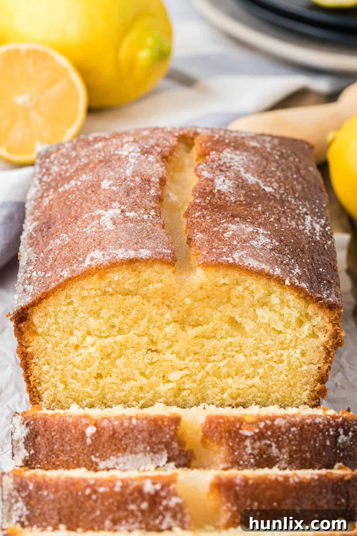 A perfectly baked lemon bread loaf, fresh from the oven, with slices cut off the end.