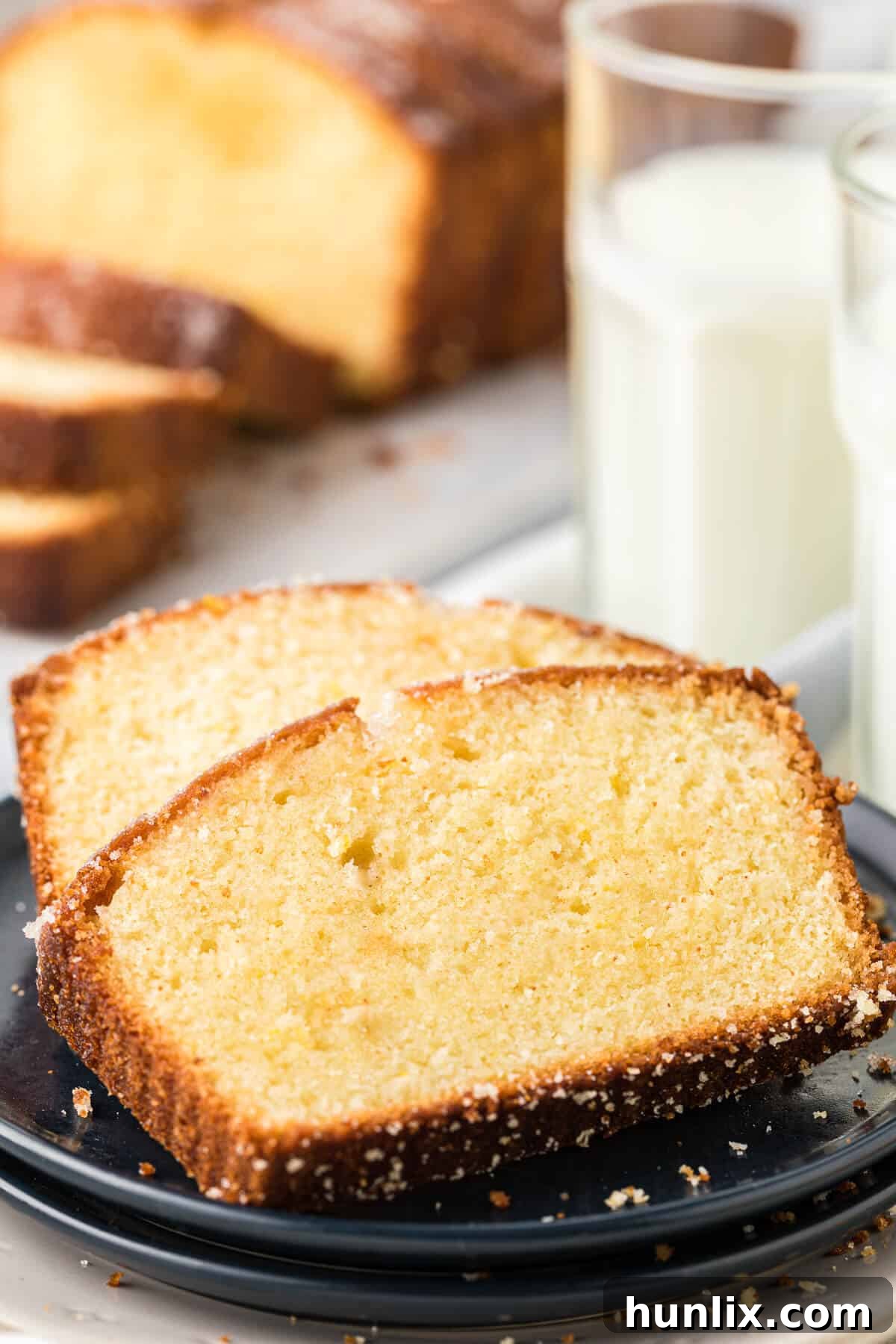 Two perfectly cut slices of lemon bread on a white plate, ready to be served.