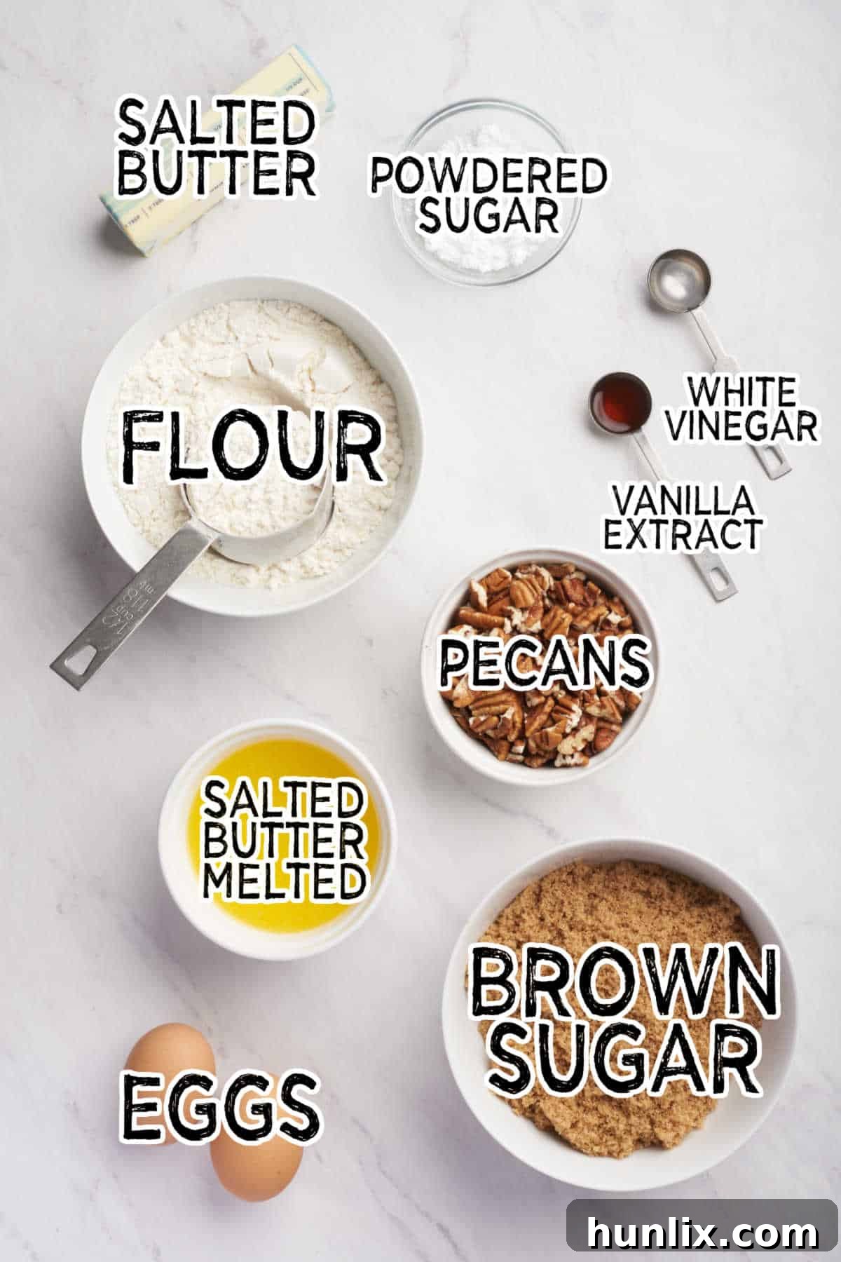 A beautiful arrangement of all the essential ingredients needed to bake Butter Tart Squares, laid out on a clean white surface.