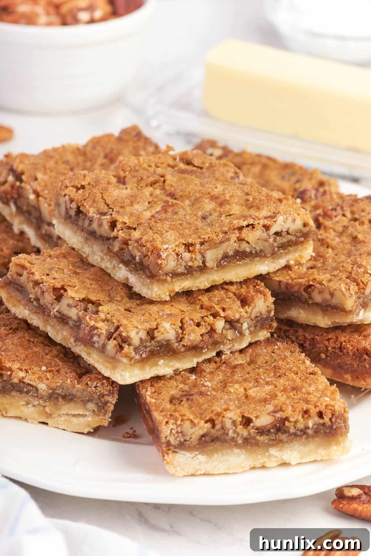 Perfectly cut Butter Tart Squares presented beautifully on a serving plate, showcasing their golden crust and rich, gooey filling.