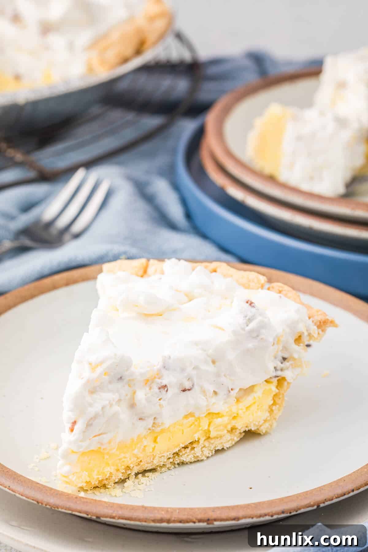 A perfect slice of Millionaire Pie served on a white plate, showcasing its distinct layers of creamy filling and golden crust, ready to be enjoyed.