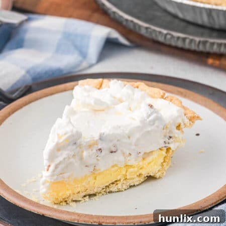 A slice of Millionaire Pie on a plate, showcasing its creamy layers and a hint of the crust.