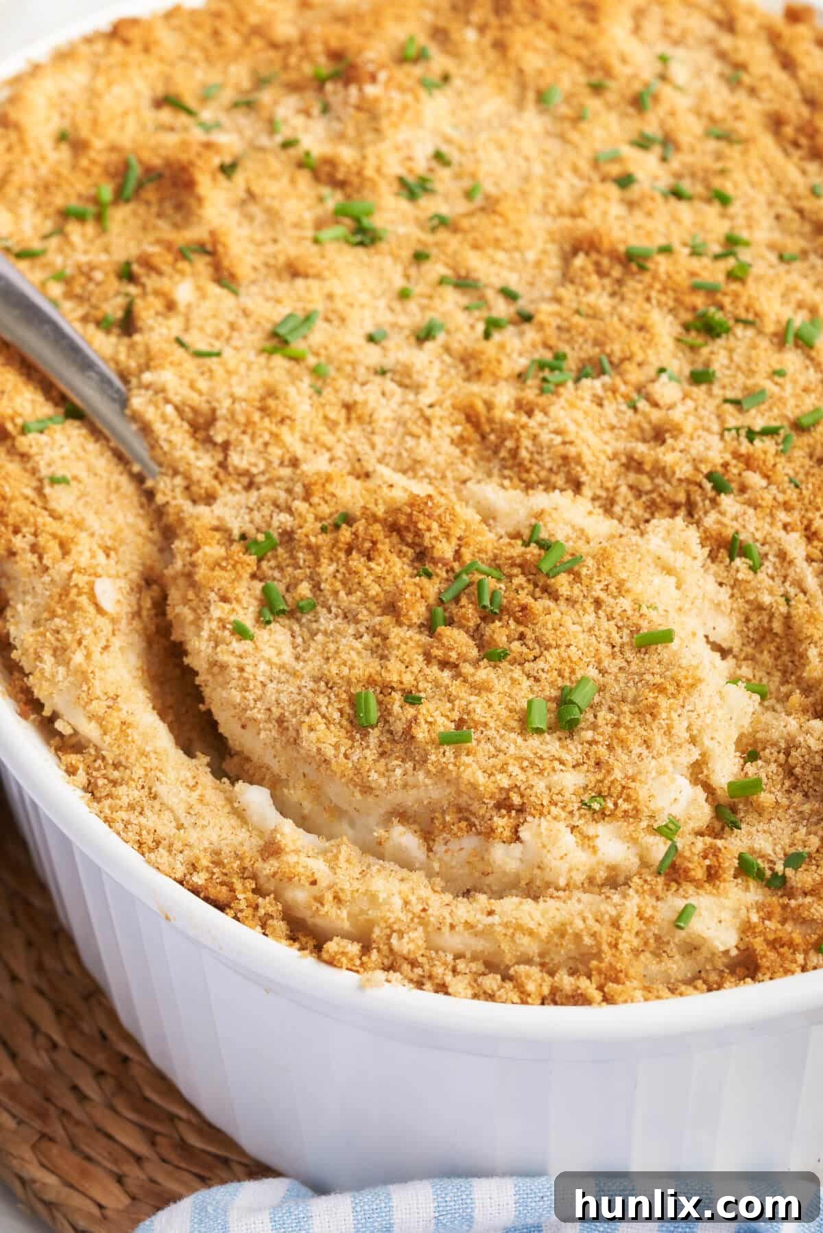 A serving spoon in a dish of Swedish potatoes.