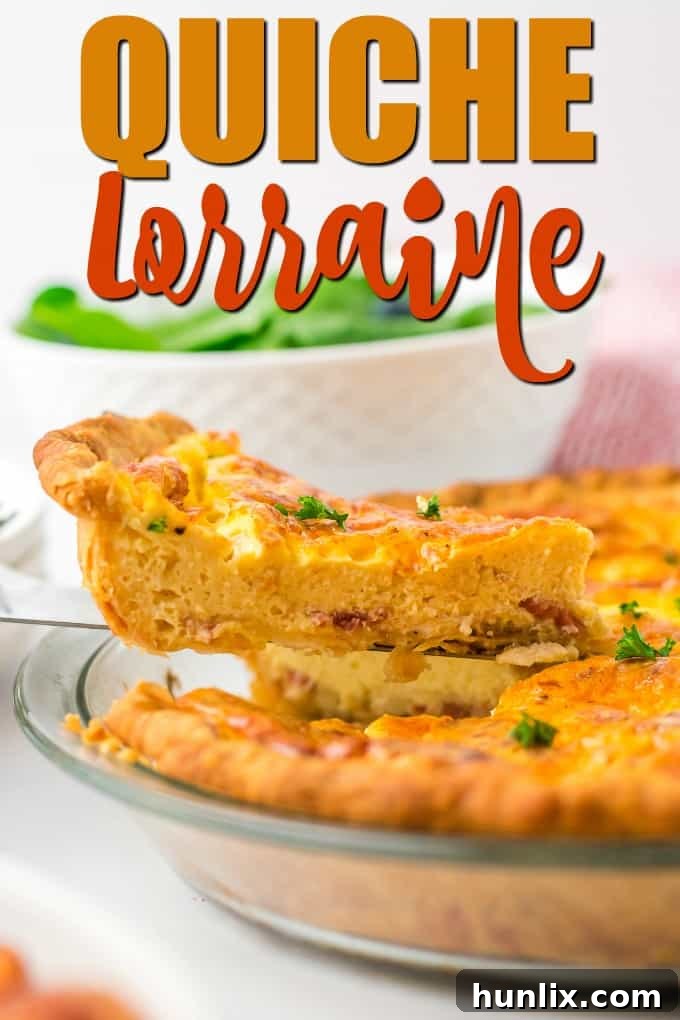 Classic Quiche Lorraine slice with flaky crust, bacon, and cheese, on a white plate