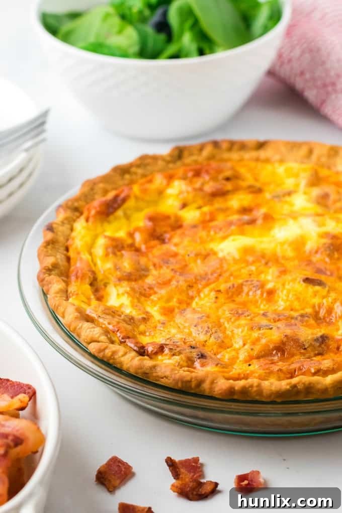 Close-up of a whole baked Quiche Lorraine, showing the golden crust and savory filling
