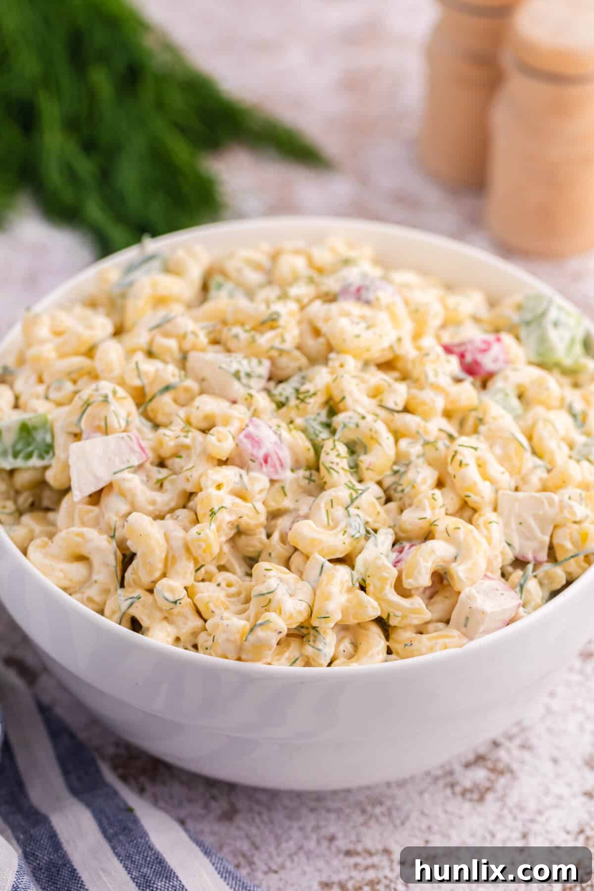 A white bowl with Macaroni Dill Salad, ready to be served.