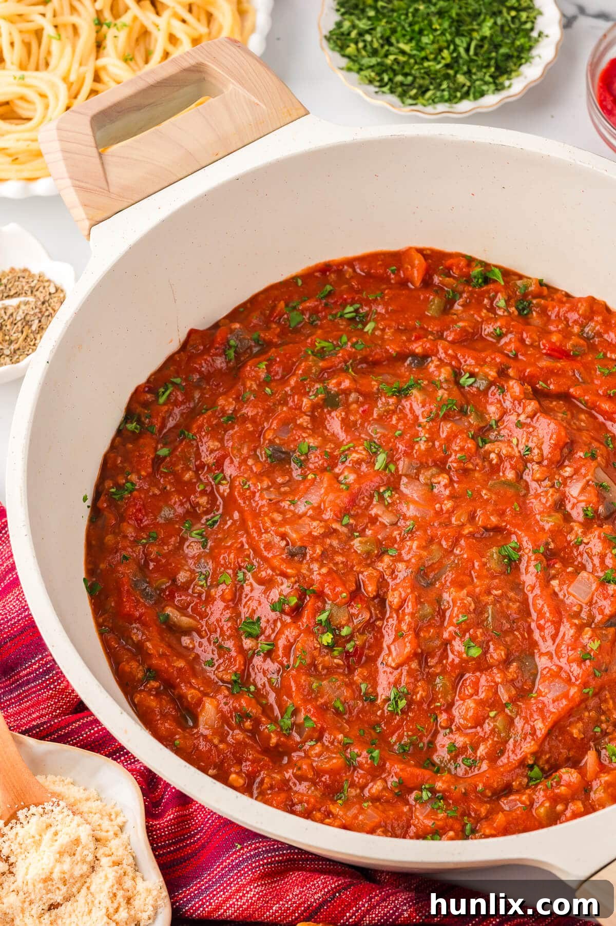 Mama's Perfect Pasta Sauce 2 A white pot of rich, simmering homemade spaghetti sauce, ready to be served.