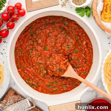 Mama's Perfect Pasta Sauce 9 A pot of homemade spaghetti sauce with a wooden spoon.