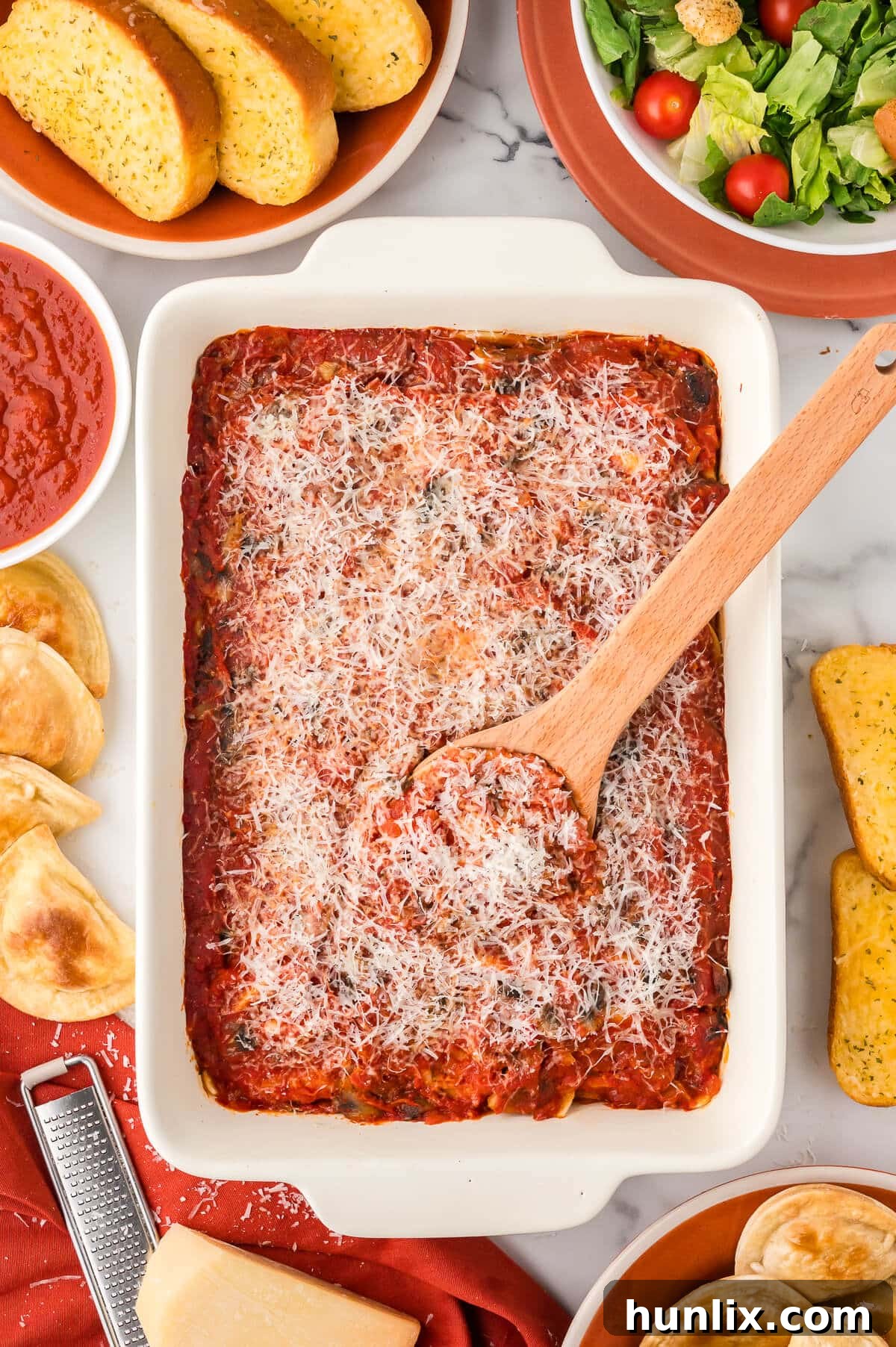 Hearty Homestyle Pierogi Casserole 2 A delicious Pierogi casserole in a pan with a wooden serving spoon, ready to be enjoyed.