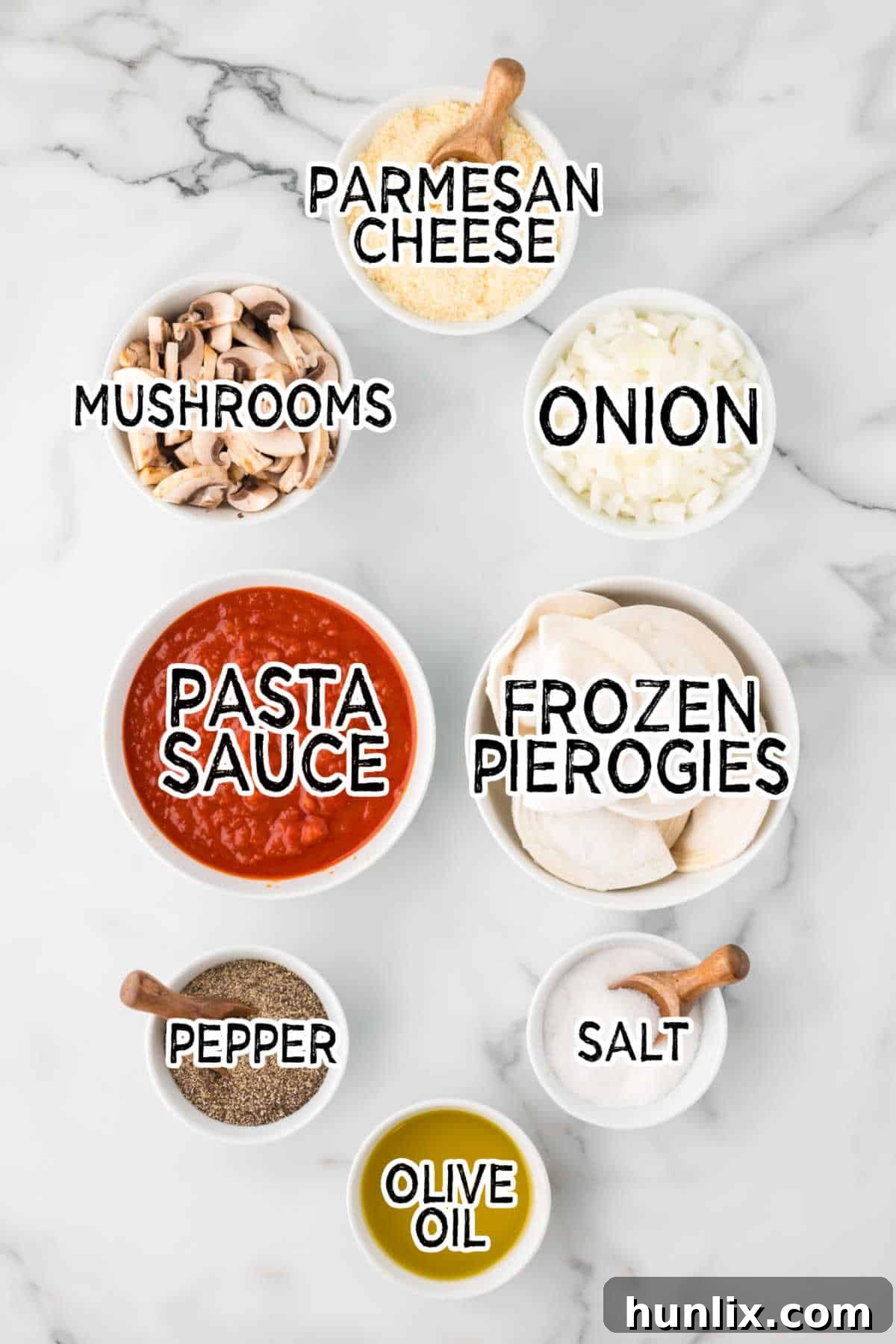 Hearty Homestyle Pierogi Casserole 3 Fresh ingredients laid out on a white counter: frozen pierogies, olive oil, sliced onions, mushrooms, pasta sauce, and a wedge of Parmesan cheese.