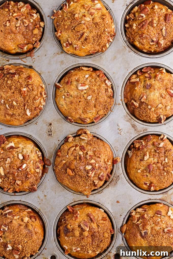 A close-up of a single Banana Streusel Muffin, showcasing its moist interior and crunchy streusel topping.