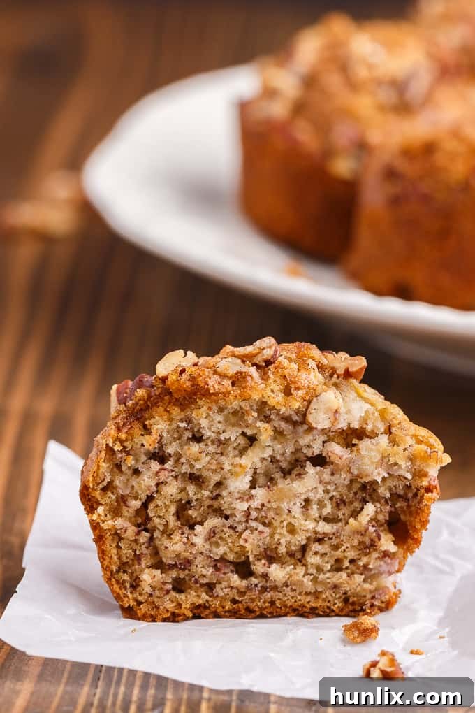 A pair of beautifully baked Banana Streusel Muffins, featuring a golden streusel crust.
