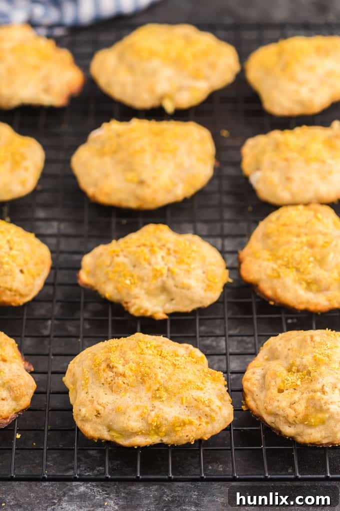 A neat stack of golden-brown banana cookies, some adorned with cornflake crumbs, on a elegant serving plate.