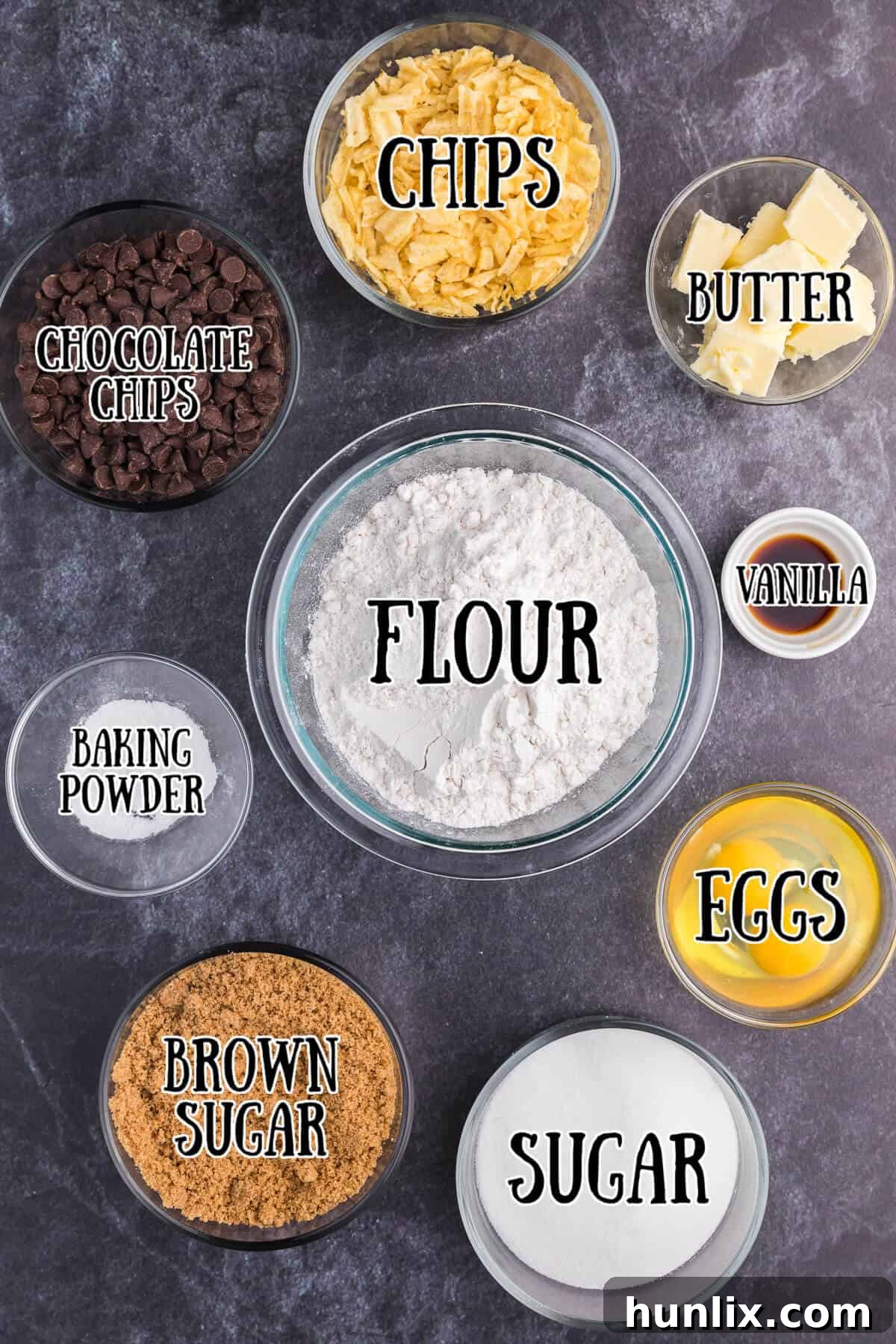 Salty Sweet Crunch Cookies 3 Assorted ingredients laid out for baking potato chip cookies, including butter, sugar, flour, eggs, chocolate chips, and potato chips.