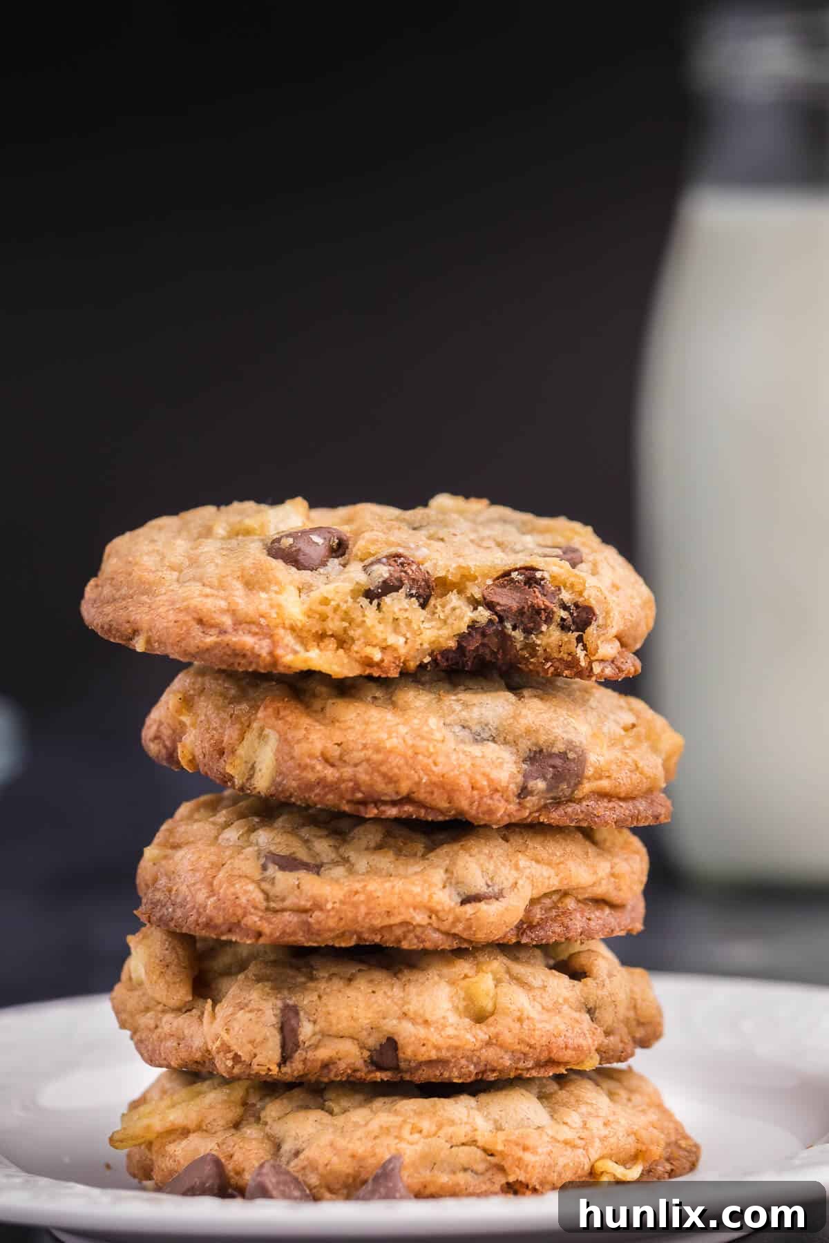 Salty Sweet Crunch Cookies 8 A close-up of a stack of potato chip cookies, showing the visible potato chip pieces and melted chocolate chips.
