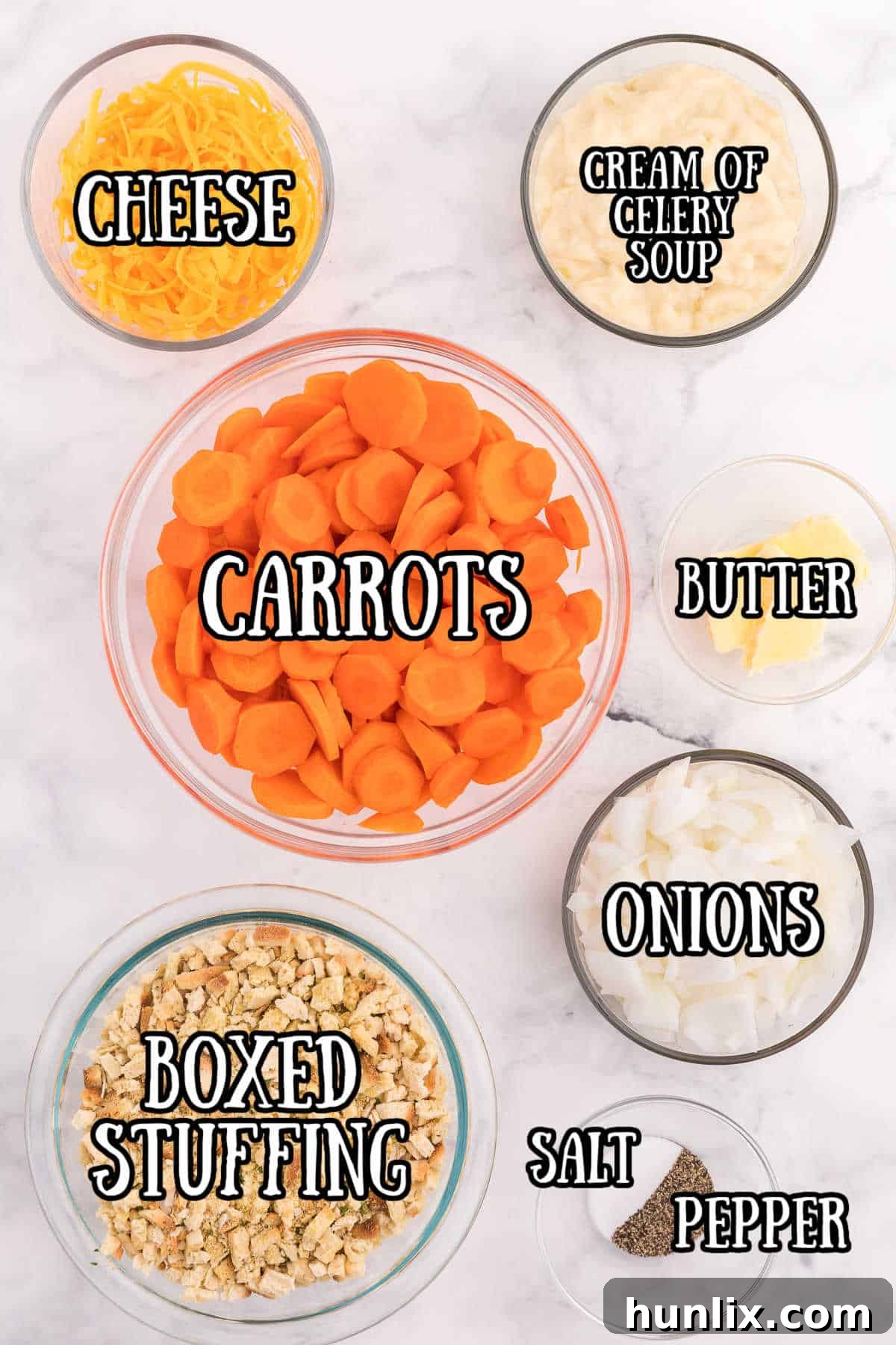 Sweet Carrot Bake 3 Carrot Casserole ingredients laid out in bowls, including sliced carrots, chopped onion, shredded cheddar cheese, and a can of cream of celery soup.