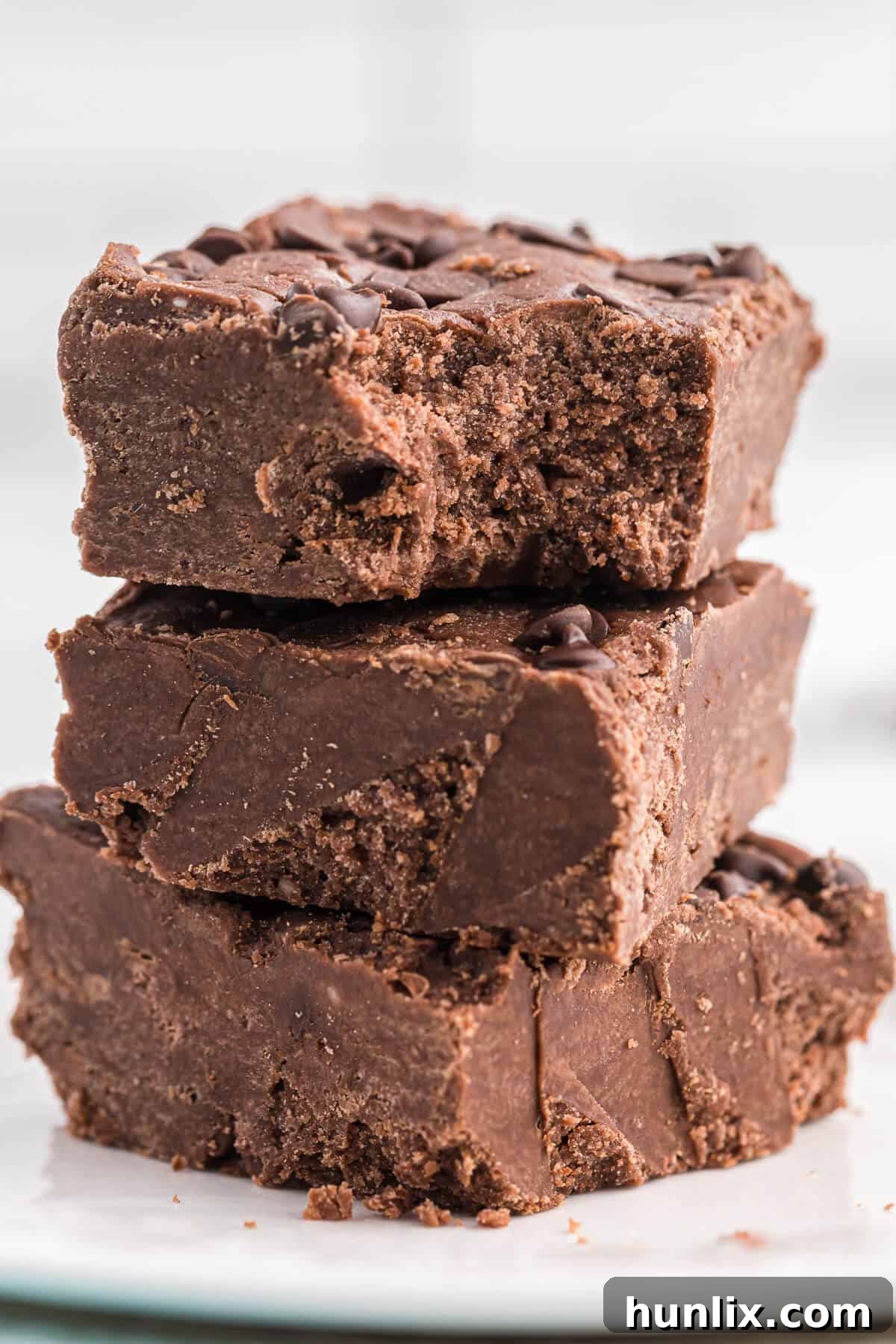 A stack of rich chocolate cake batter fudge squares, perfectly set and ready to enjoy.