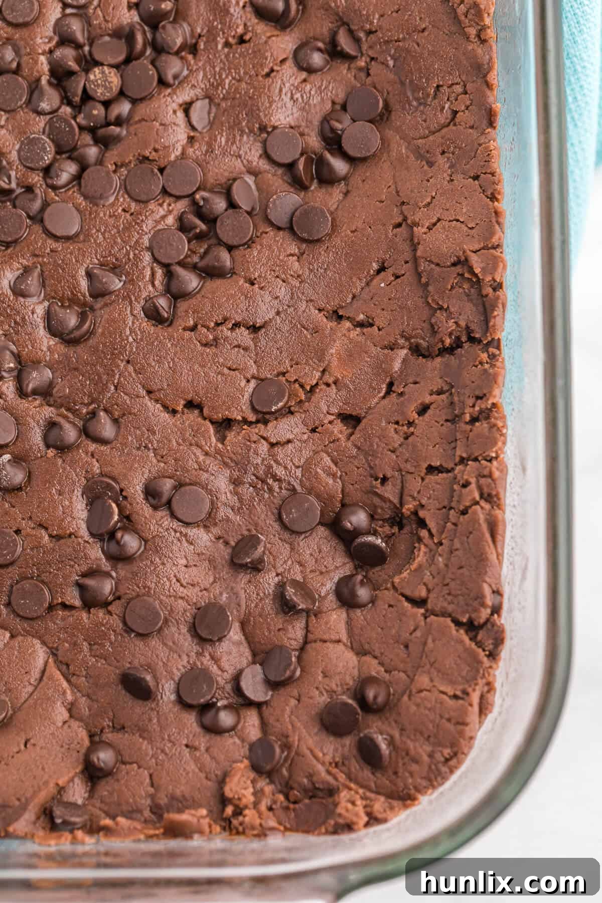 The finished chocolate cake batter fudge cooling in a baking pan, ready to be cut.