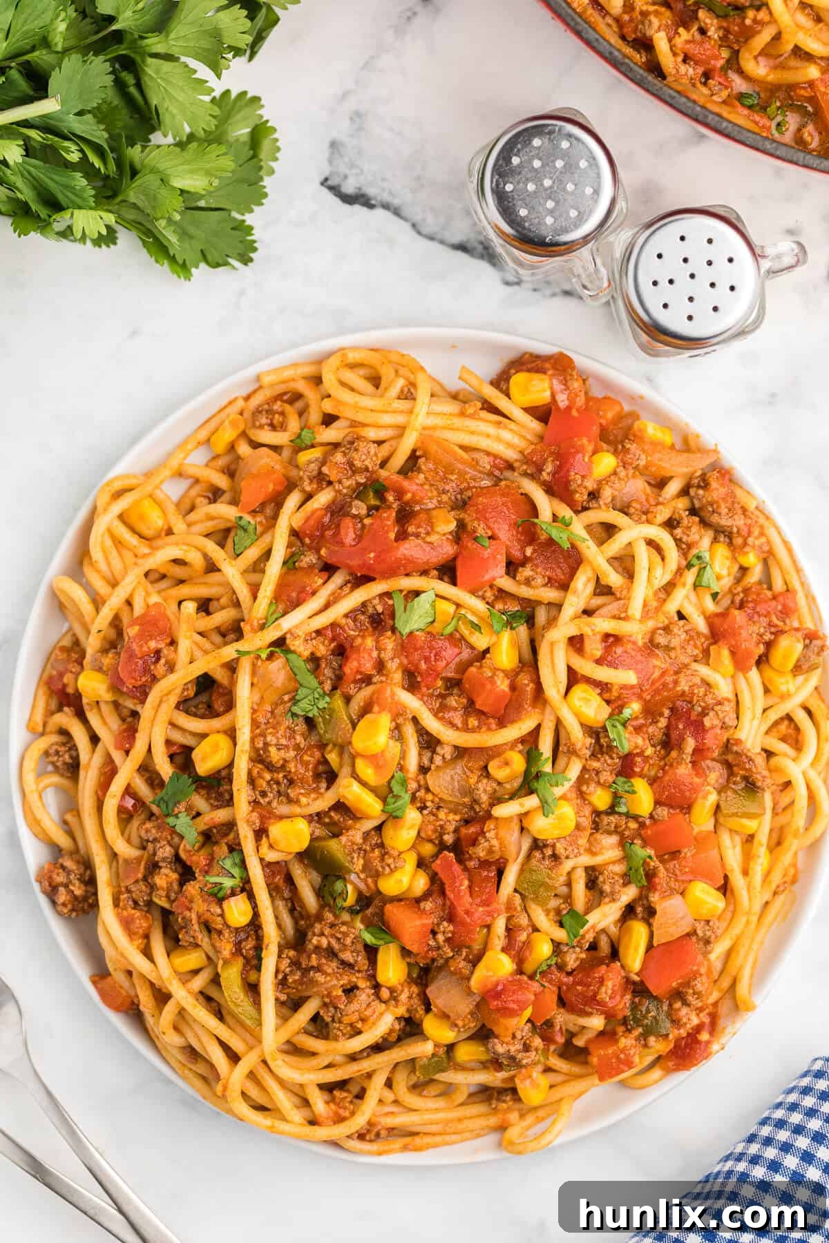A portion of Mexican spaghetti served on a white plate, showcasing its vibrant ingredients.