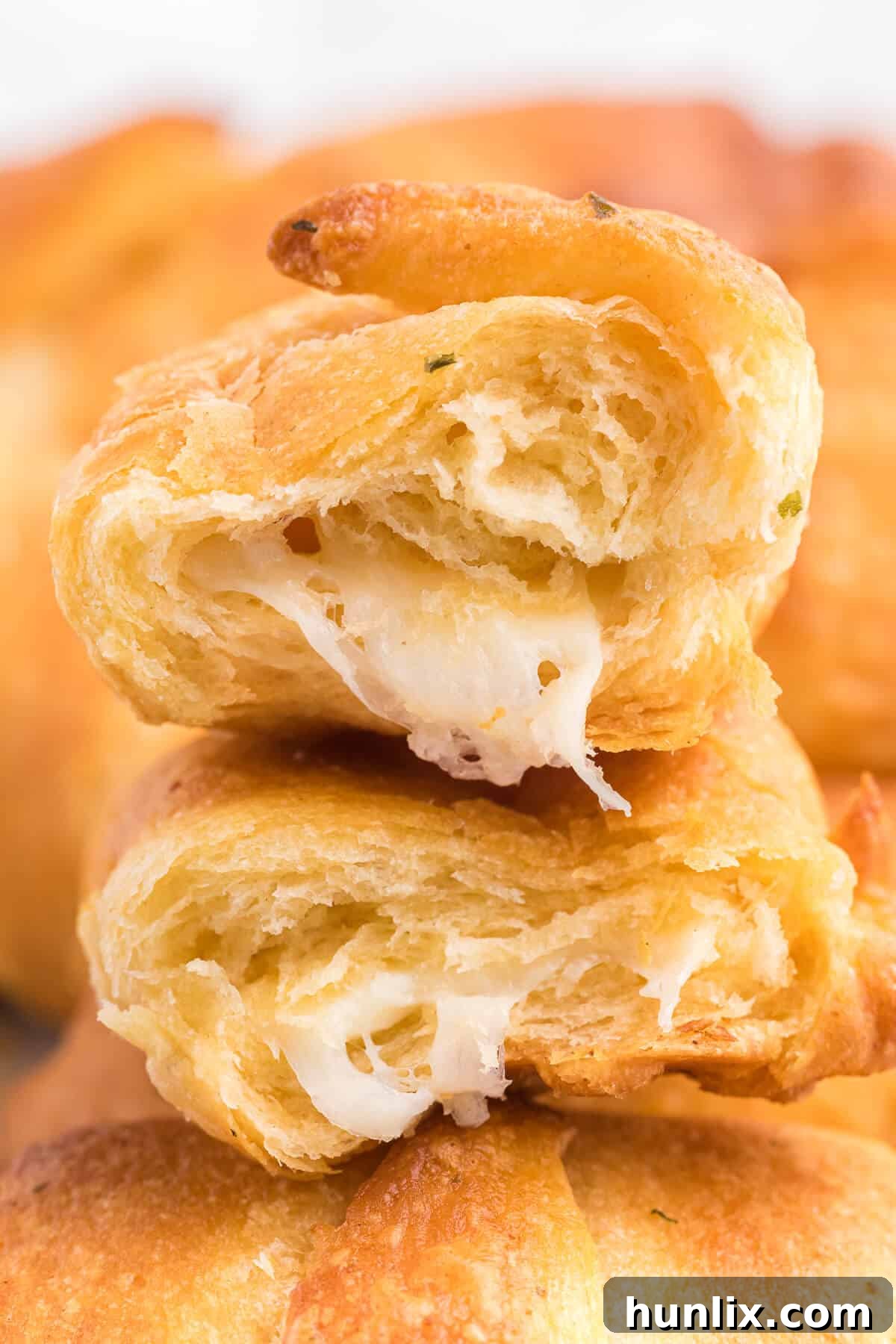 A stack of golden brown Air Fryer Garlic Cheese Stuffed Crescent Rolls, tempting and ready to eat.
