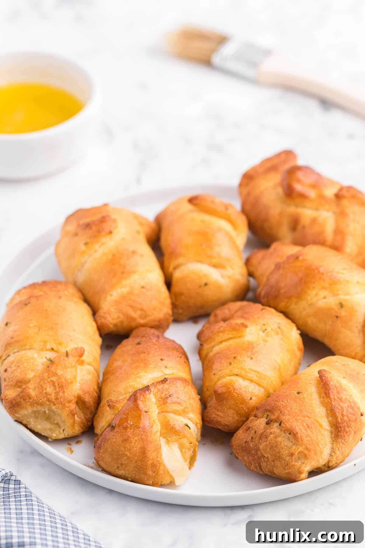 Air Fryer Garlic Cheese Stuffed Crescent Rolls piled on a white plate, showcasing their golden crust and cheesy interior.