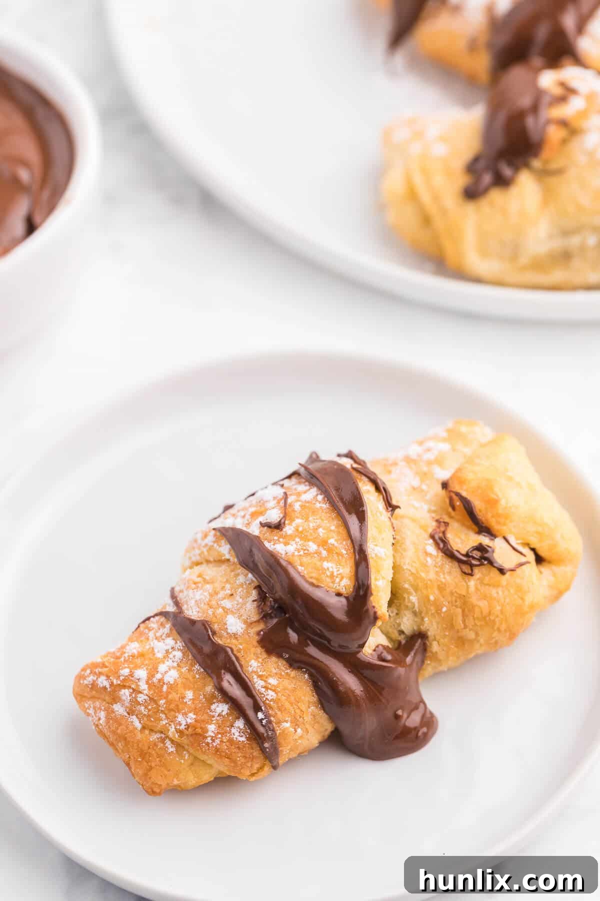 Perfect Air Fryer Chocolate Croissants 10 Several Air Fryer Chocolate Crescent Rolls artfully arranged on a white plate, showcasing their golden crust and melted chocolate.