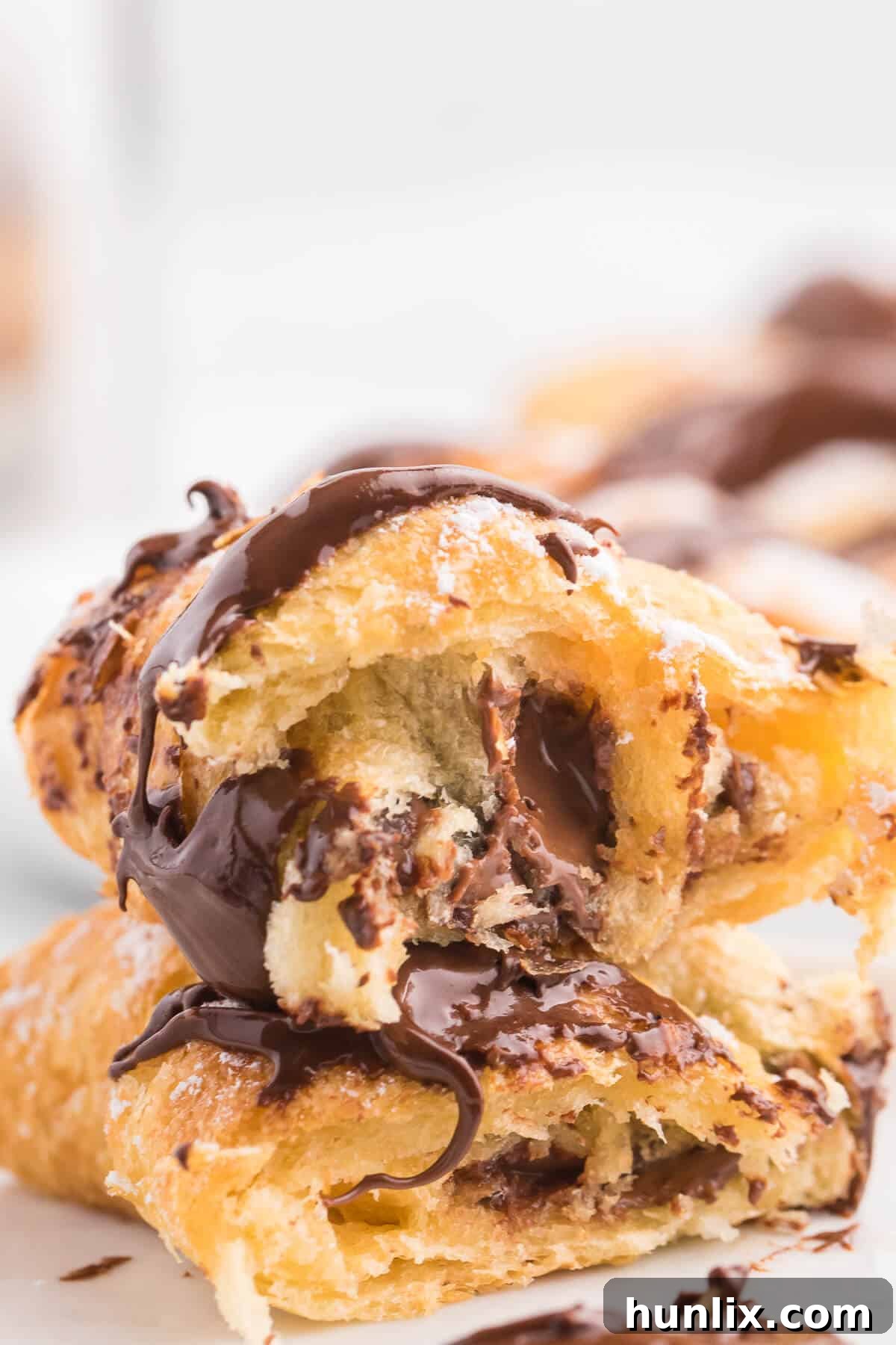 Perfect Air Fryer Chocolate Croissants 11 A close-up shot of an Air Fryer Chocolate Crescent Roll cut in half, revealing the warm, melted Nutella filling inside.