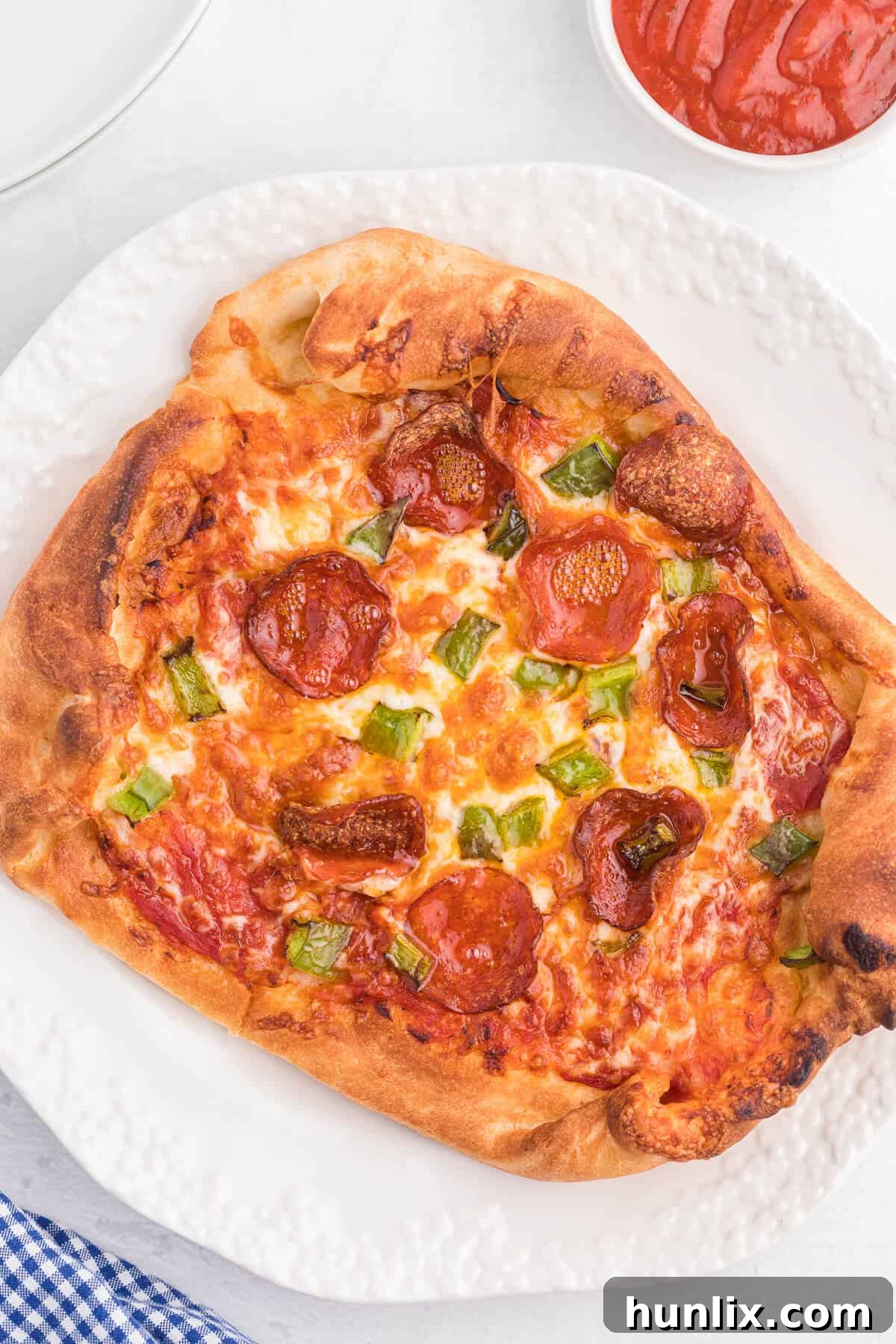 Freshly cooked Air Fryer Pizza on a plate, showing a crispy crust and melted toppings.