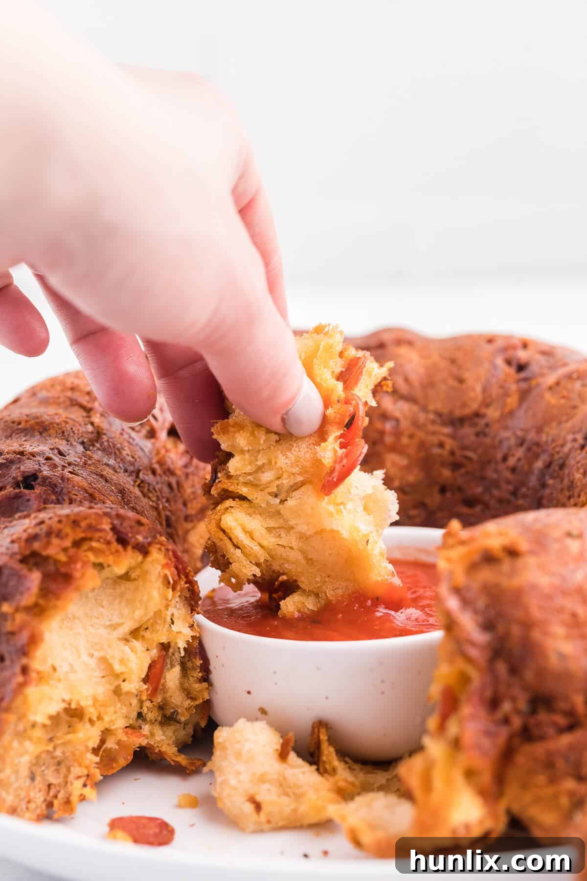 Close-up view of a hand pulling a piece of Pizza Monkey Bread
