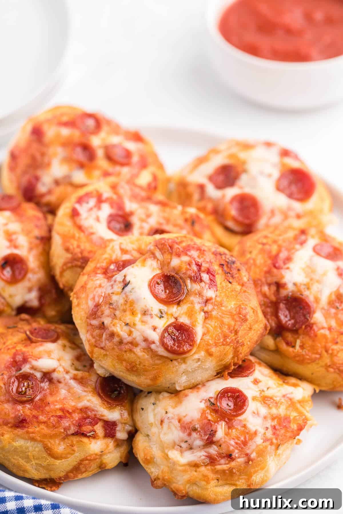 Irresistible Air Fryer Pizza Buns 7 Air fryer pizza buns resting on a white plate, ready to be served.