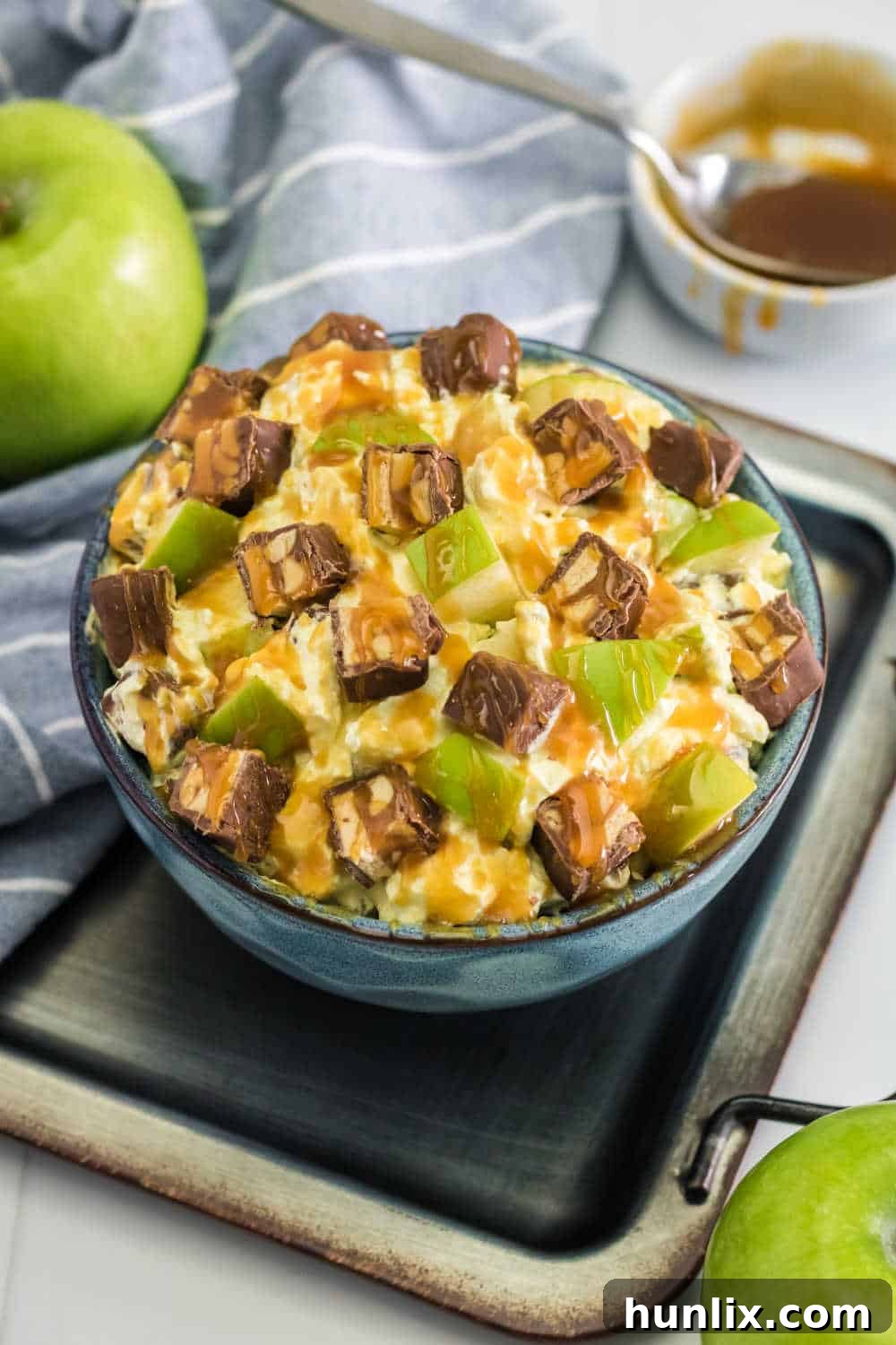 Creamy Caramel Snickers Apple Salad 7 A vibrant bowl of Snickers Salad with a variety of textures, inviting customization, presented on a metal baking pan.
