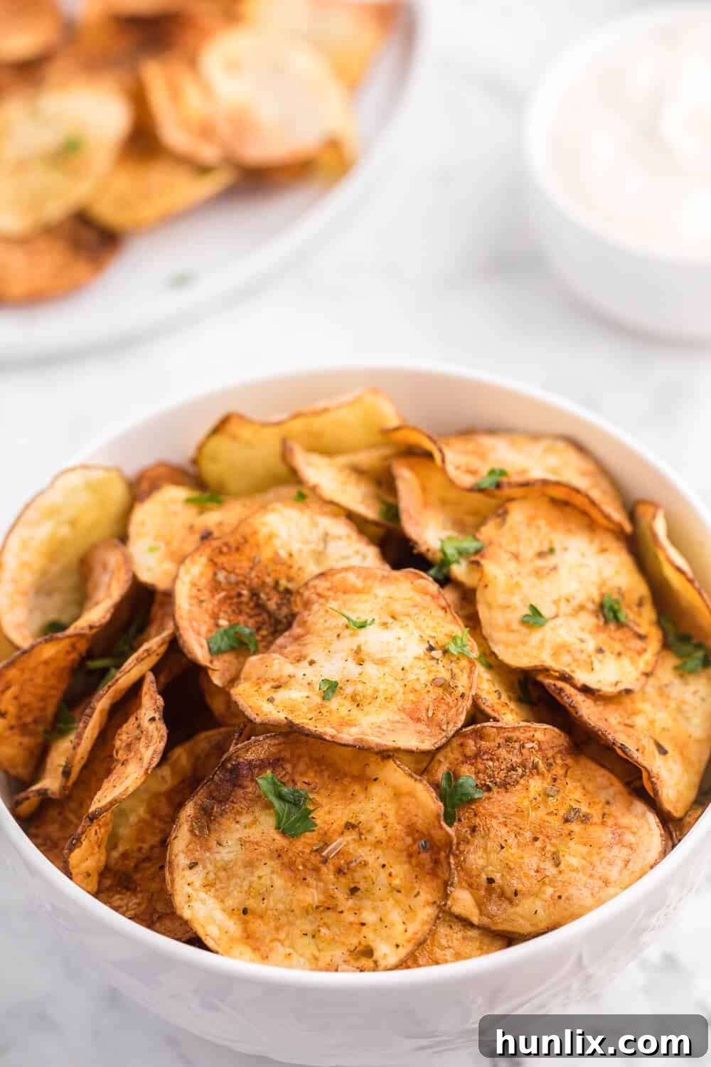 Homemade Air Fryer Potato Chips served in a white bowl.