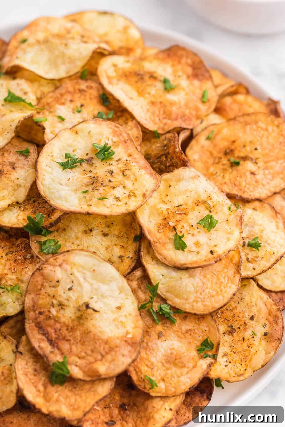 Another view of the crispy Air Fryer Potato Chips on a plate, ready to be enjoyed.