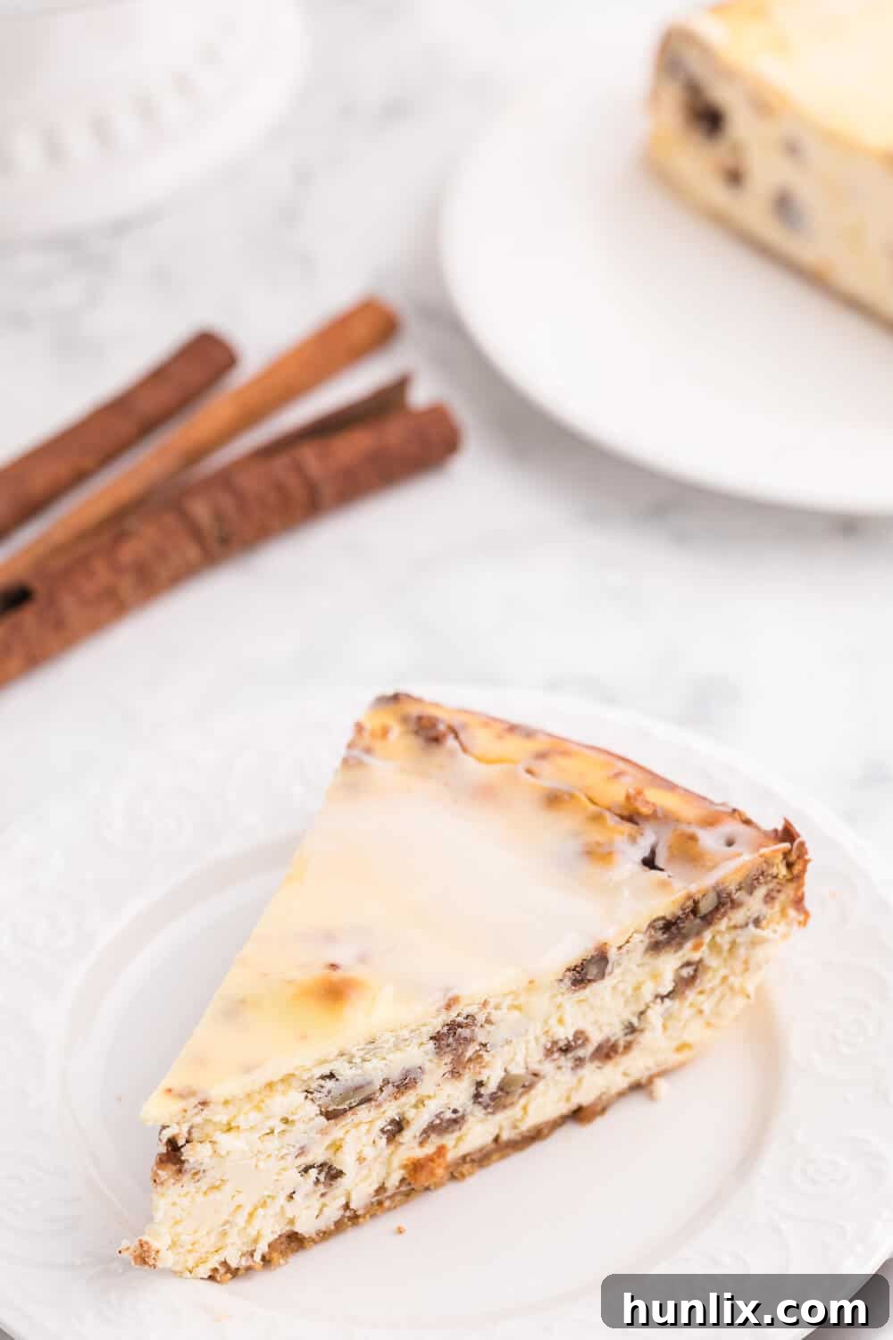 A mouth-watering slice of cinnamon roll cheesecake showcasing its creamy filling and spiced layers.