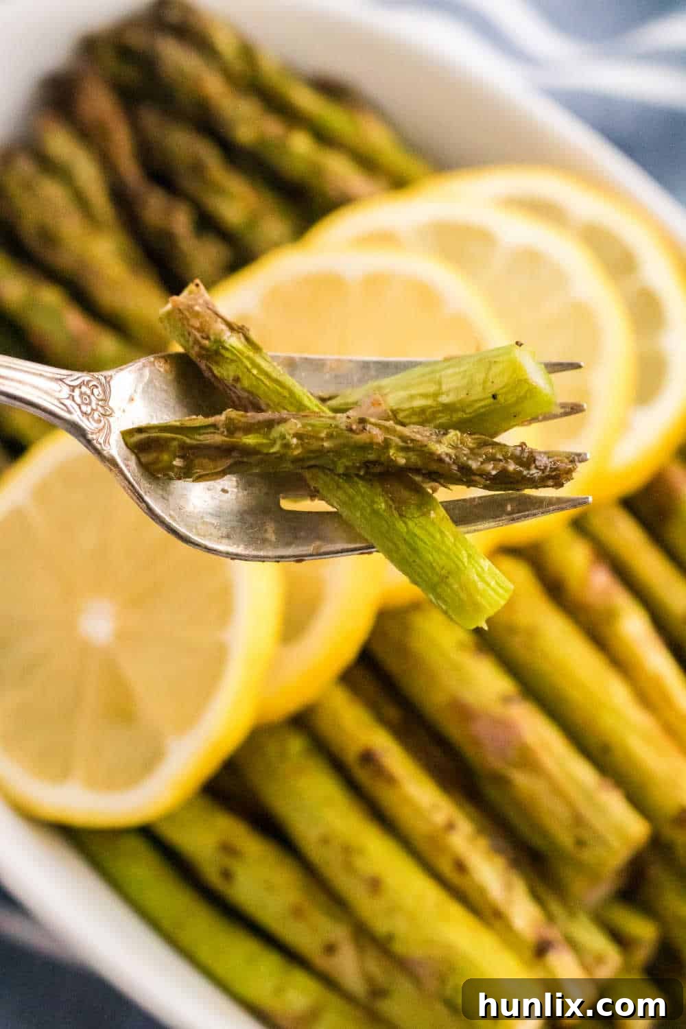 A single air fryer asparagus spear on a fork.