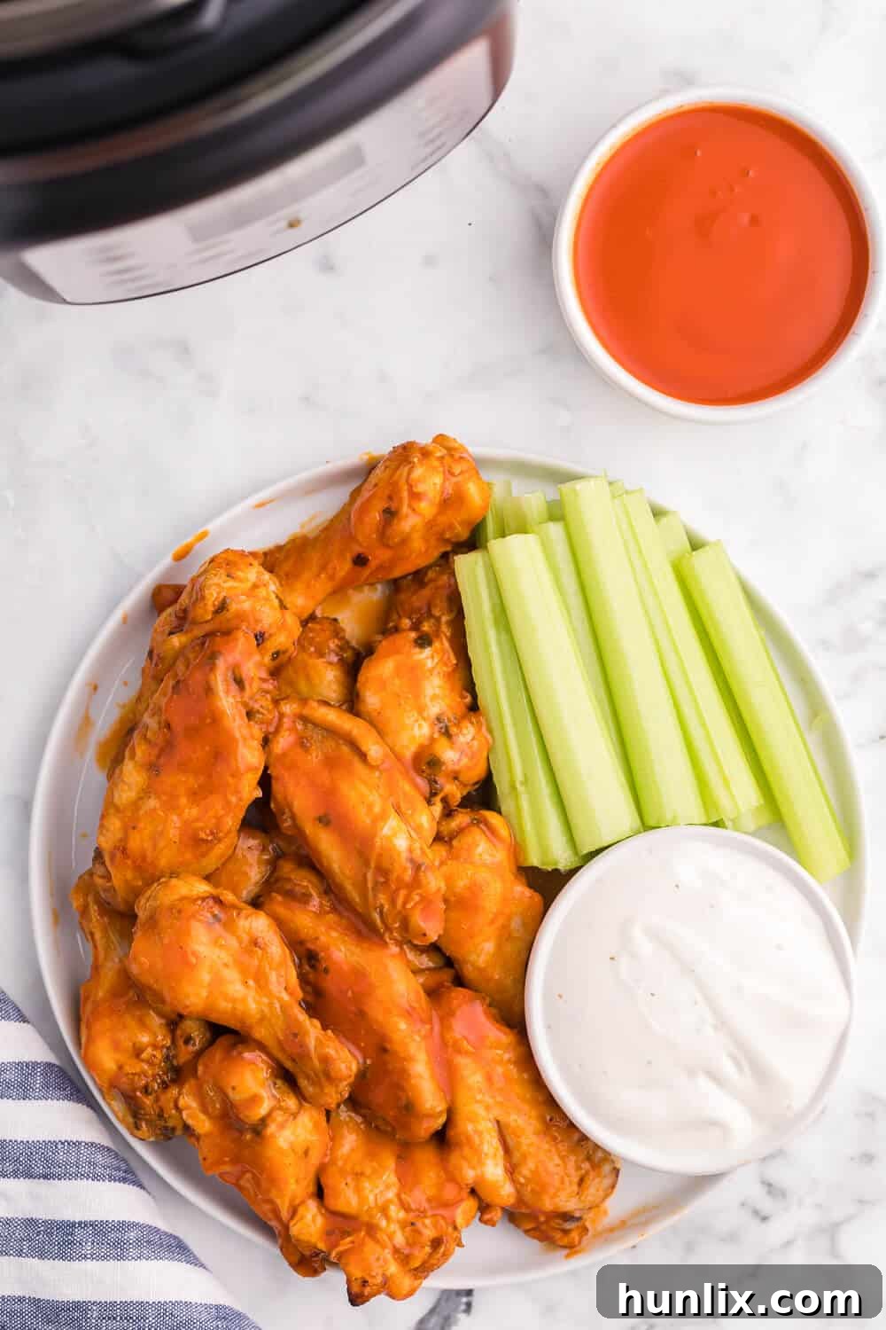 Air Fryer Buffalo Chicken Wings served on a plate with fresh celery sticks and a side of creamy ranch dip.