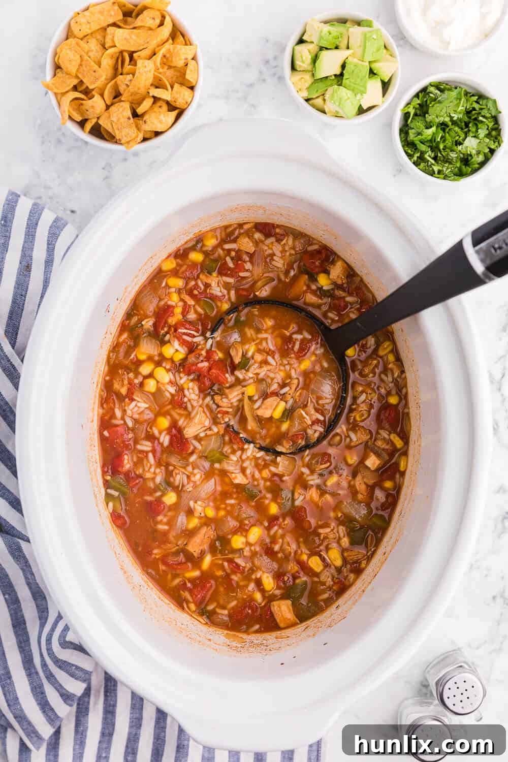 Southwest chicken and rice soup in a white slow cooker with a ladle