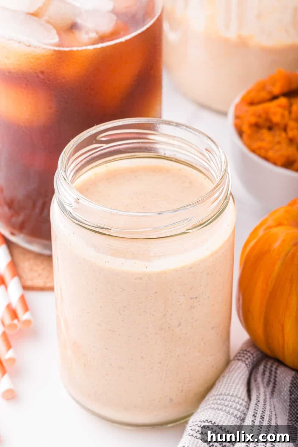 Velvet Pumpkin Coffee Swirl 2 A glass jar filled with homemade pumpkin spice creamer, ready to be added to coffee or other fall beverages.