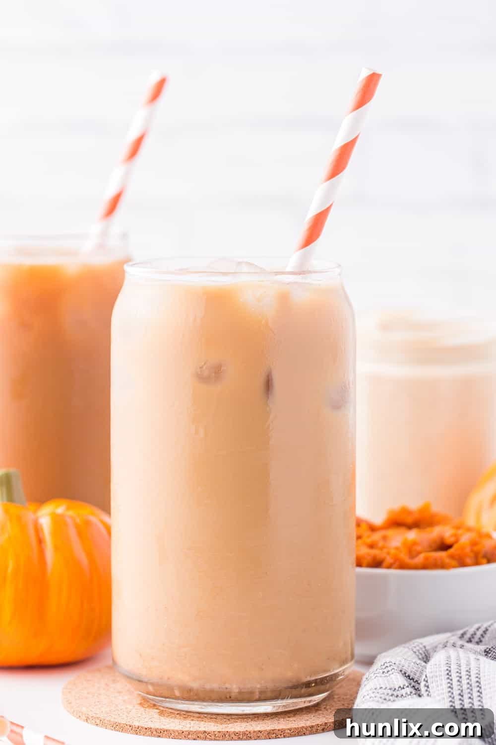 Velvet Pumpkin Coffee Swirl 7 Two glasses of iced coffee, each with a straw, featuring pumpkin spice creamer for a refreshing fall drink.