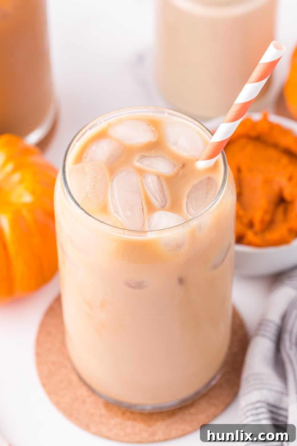 Velvet Pumpkin Coffee Swirl 8 A close-up of iced coffee in a glass jar, perfectly blended with homemade pumpkin spice creamer.