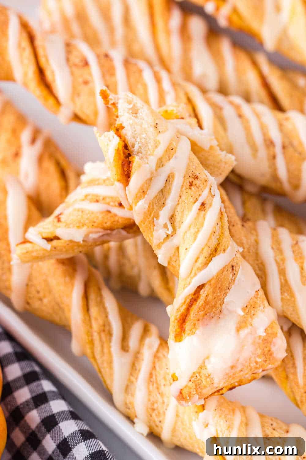 A close-up shot of an Air Fryer Pumpkin Pie Twist broken in half, revealing the soft, delicious pumpkin filling inside.
