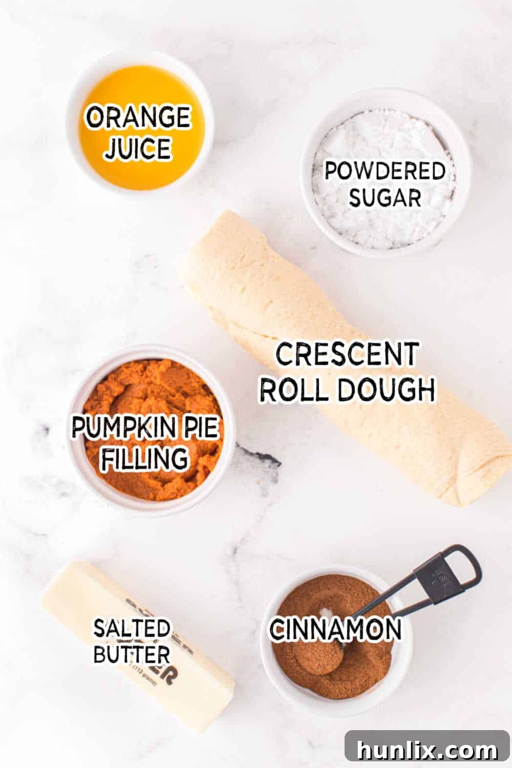 A vibrant flat lay of all the fresh ingredients needed for Air Fryer Pumpkin Pie Twists arranged on a clean white background.