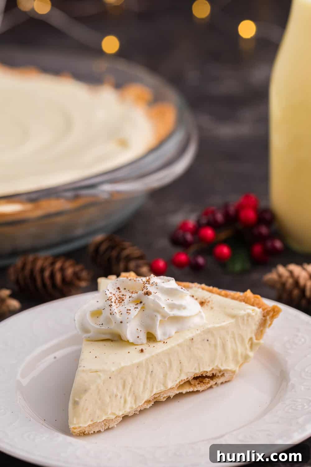 A beautifully presented slice of eggnog pie on a white plate, ready for dessert.